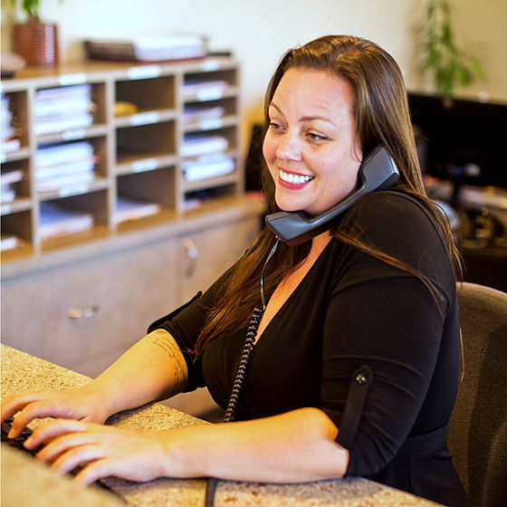 A staff member on the phone at the front desk