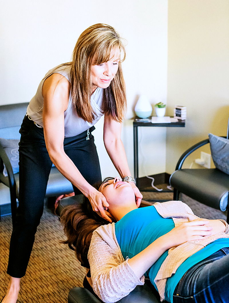 A practitioner treating a patient lying on a table